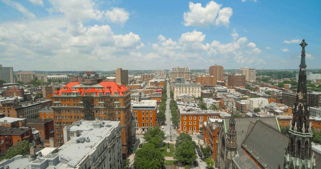 A high-angle view of historic Baltimore rooftops emphasizing the expertise required by local vs. corporate roofing companies.