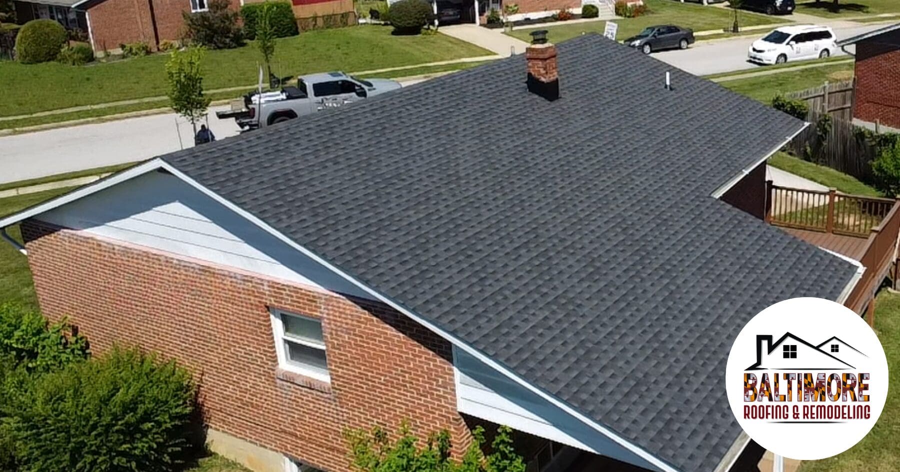 Aerial drone view of a newly installed architectural shingle roof on a brick residential home in Baltimore County, completed by Baltimore Roofing & Remodeling after a comprehensive spring storm roof audit.
