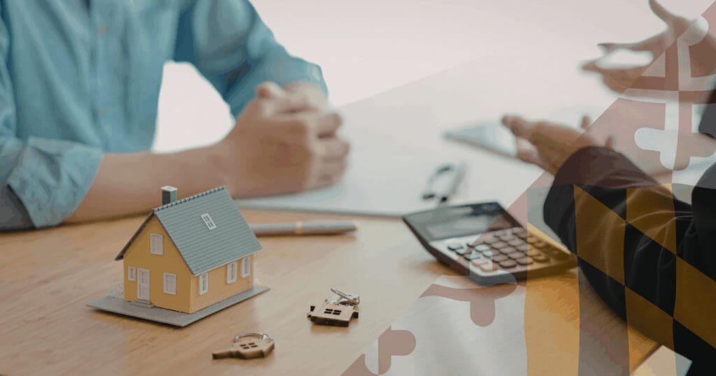 A homeowner and a local roofing consultant sitting at a desk reviewing financial documents and a calculator, with a miniature yellow model house and keys resting in the foreground. This meeting represents the strategic planning necessary when dealing with an insurance company forcing roof replacement, Maryland families need flexible financing to secure their property. A translucent Maryland flag pattern is overlaid on the right.