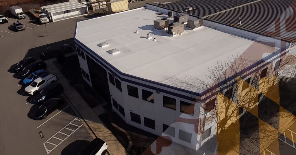An expansive commercial flat roof utilizing a white TPO thermoplastic membrane to protect a massive warehouse facility. Heavy rooftop HVAC units frequently compress the underlying metal decking over time, requiring routine geometric sloping to prevent structural depressions and standing water from destroying the commercial inventory below.