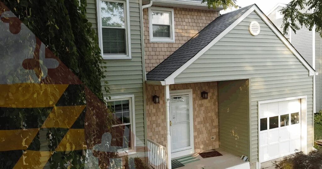 A multi-level Maryland home demonstrating the critical architectural intersection where a lower asphalt roofline dead-ends directly into a vertical siding wall. Executing a concurrent exterior upgrade allows our local crews to properly install metal step flashing completely behind the new siding panels, effectively blocking lateral moisture migration.