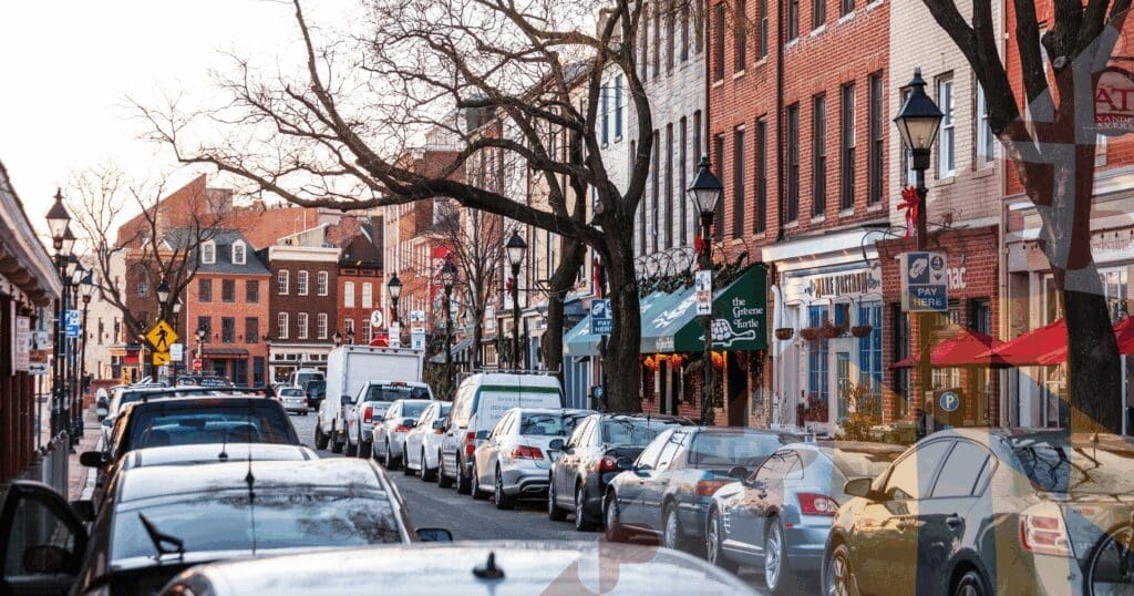 A street-level view of historic brick rowhomes tightly packed along a downtown Baltimore City street. Protecting these unique urban properties requires specialized diagnostic expertise to ensure flat roof membranes correctly integrate with the shared masonry parapet walls to prevent lateral water intrusion.