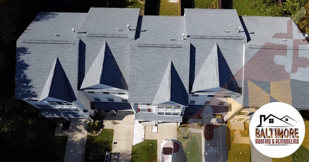 Top-down aerial perspective of a shared townhouse roofing system, illustrating the broader structural impact and domino effect severe weather can have on connected architecture across Baltimore County when repaired by unvetted, out-of-state laborers.
