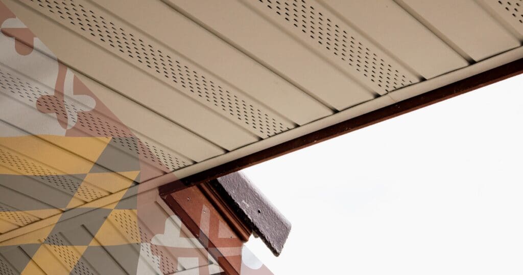 Close-up of perforated soffit intake vents on a roof overhang, providing critical airflow to regulate attic temperatures and prevent winter thermal failures.